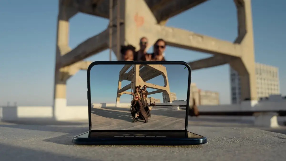 Smart Take uses AI to detect the moment everyone in the frame is ready and takes the shot for you. Fold the phone halfway, stand it up, and run into the picture — no timer, and nobody has to stay behind the camera.